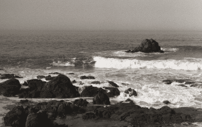 fotografia do mar quebrando em pedras na praia